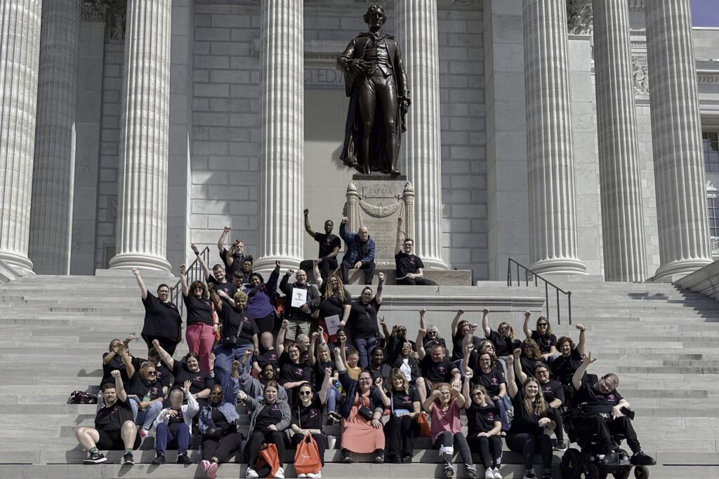A vibrant group of 60 Emmaus advocates cheerfully posing on the Missouri State Capitol steps for Disability Rights Legislative Day.
